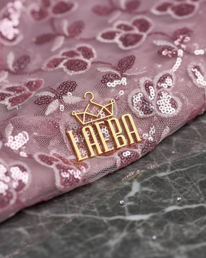 Extreme close-up of pink lace fabric with luxury gold Laeba pin